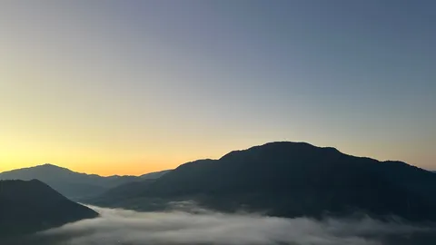 朝焼けと霧の山影