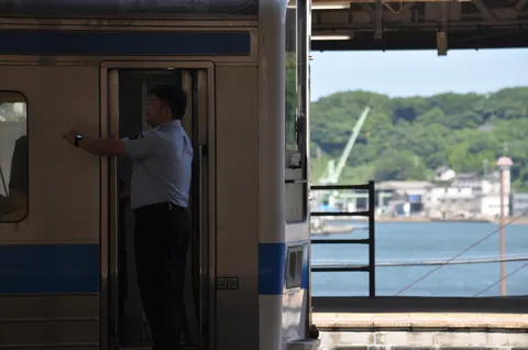 駅員の背中に沿線の風