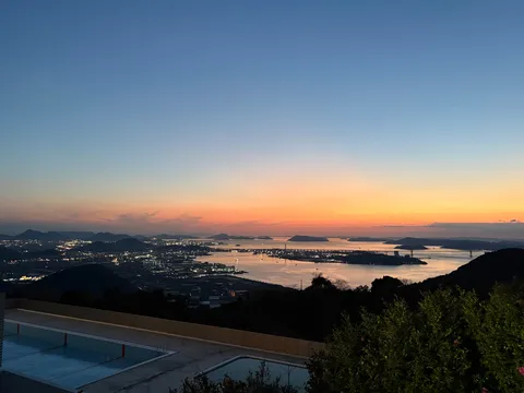 夕暮れに灯る街と海、二つのプール