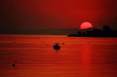 燃えるような夕陽、静かな水面