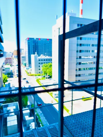都会の空と窓越しの風景