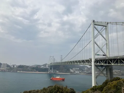 湾を渡る白き大橋と船