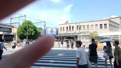 青空の下、横断歩道を行き交う人々