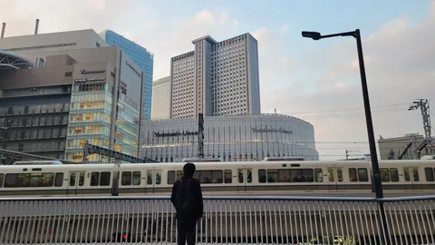 都会の交差点、電車を待つ人