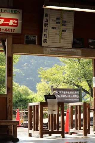 駅の時刻表と緑の山々