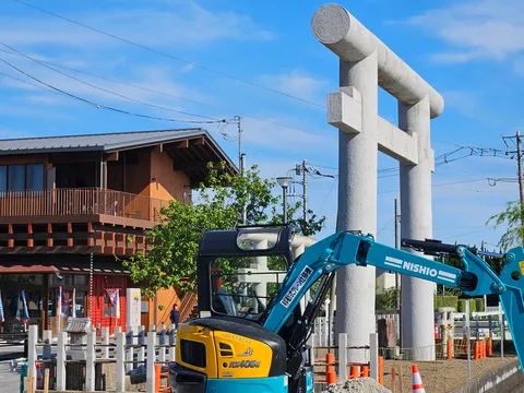 建設現場と神聖な鳥居のコントラスト