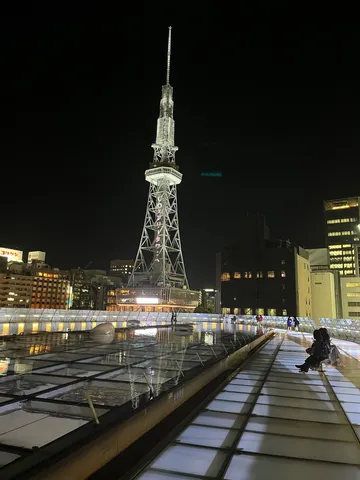都会の夜景に映えるタワーと水面
