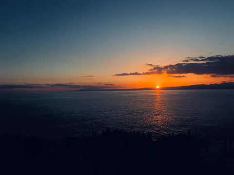 水平線に沈む夕日とシルエット
