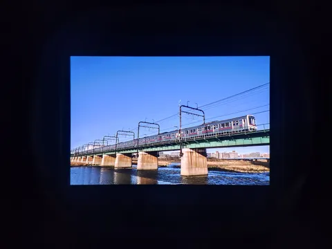 青空の下、鉄橋を渡る電車