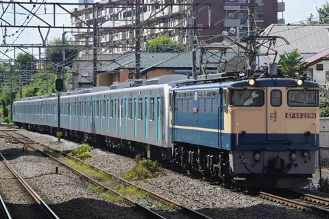 架線網を背に走る青い列車