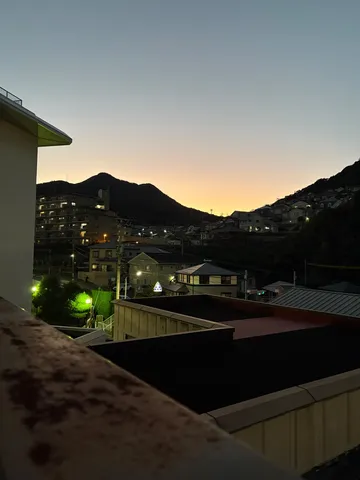 夕暮れの街と山影