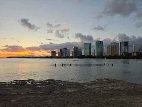都会の岸辺、夕焼けに染まる