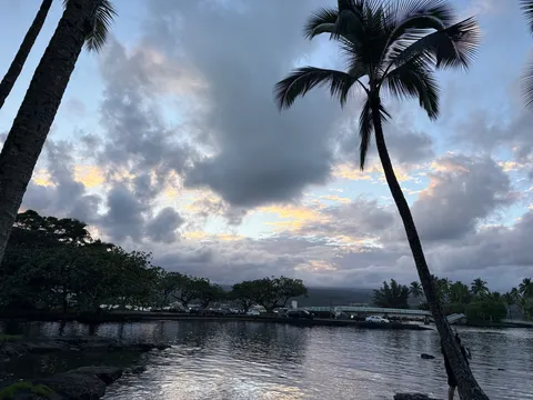 雲間の光とヤシの水辺