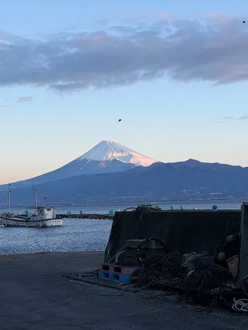 湖畔に佇む漁船と雄大な富士山
