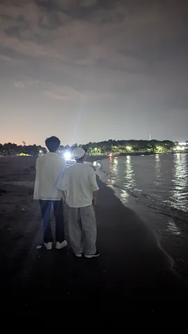 夜の海岸で語り合う二人