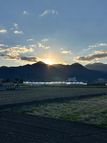 夕陽が照らす里山の温室