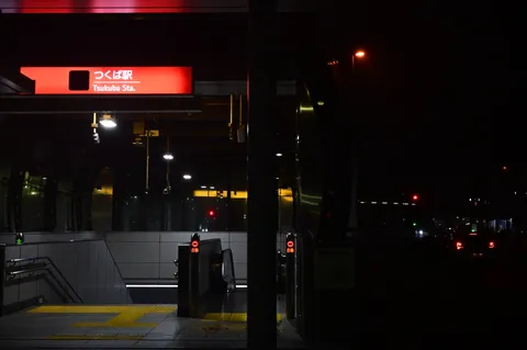 夜の駅に灯る赤い看板