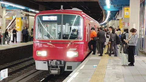 赤い列車が迎えるホームの風景