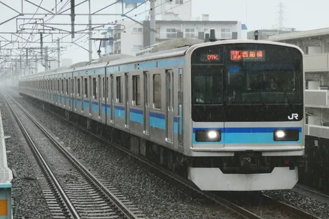 雨の路線を伸ぶ列車群