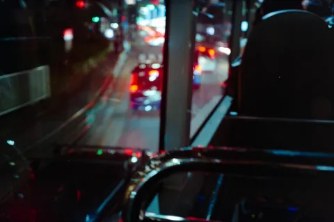 夜の車窓に映る赤い灯