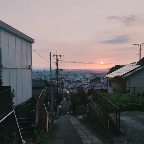 夕暮れの坂道、街に溶ける空