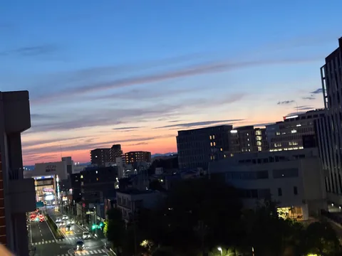 都会の空に灯る、一日の終わりのオレンジ
