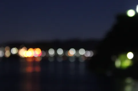 夜の水辺に揺れる灯り