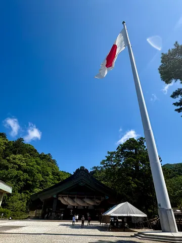 青空に舞う日の丸、神社の威厳