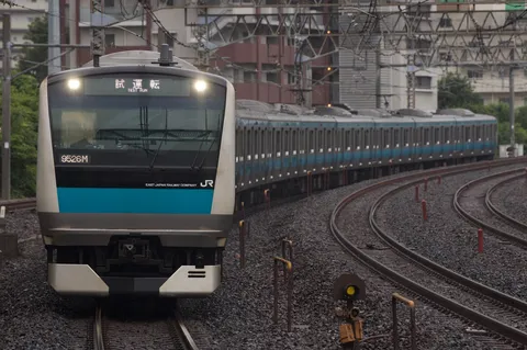雨の中を駆ける青い帯の電車