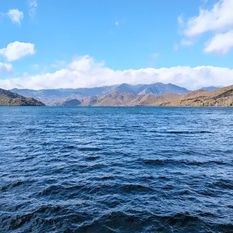 青い水面と秋色の山並み