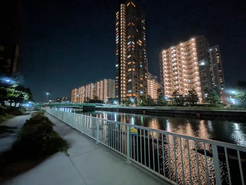 都会の灯りが水面に揺れる夜景