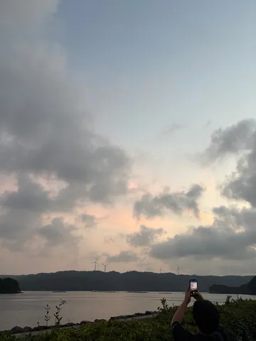 風力発電と静かな水辺の夕暮れ