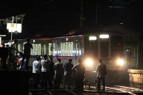 深夜の駅、人々と列車