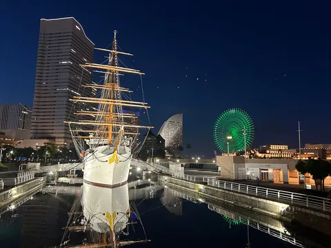 港に佇む帆船と夜の観覧車