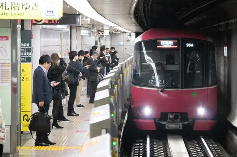 赤い電車と、夢中のスマホ隊