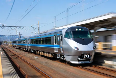青空の下、駅を通過する列車