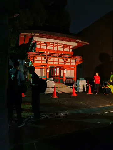 夜の神社、人影と提灯の光