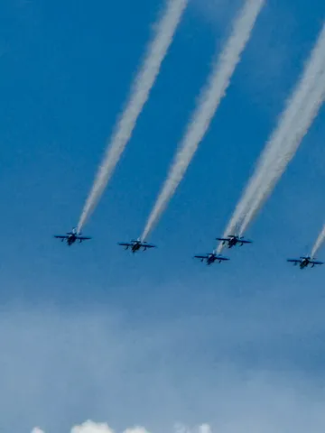 白い飛行線が並ぶ空