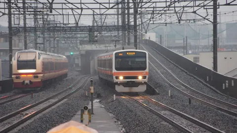 雨の線路を走る列車の影
