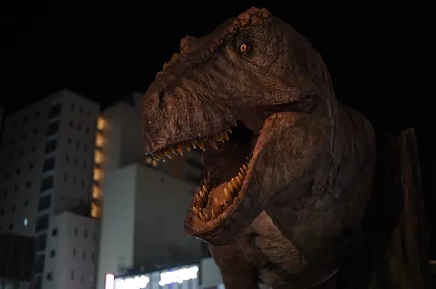 夜の街角に牙をのぞかせる恐竜