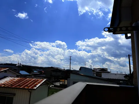 青空に映える雲と町の日常