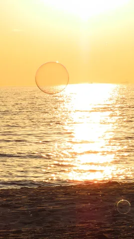 海辺に浮かぶシャボン玉の幻想的な夕暮れ