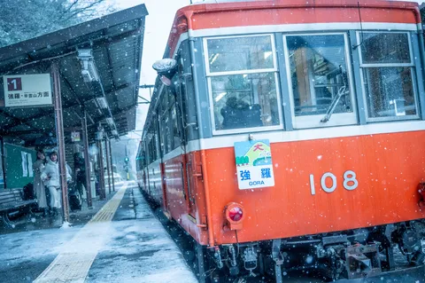 雪舞う駅に佇む赤い列車
