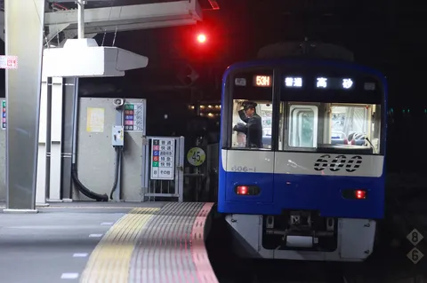 夜のホームを走る青い列車