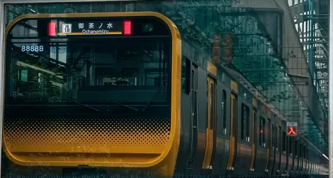 緑を映す都心の列車