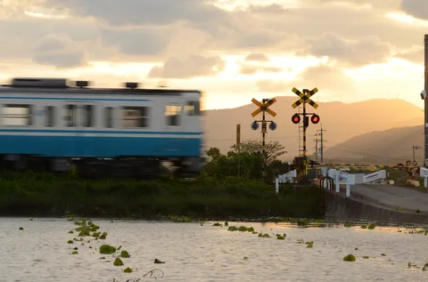 夕焼けを横切る列車、水辺に輝く情景