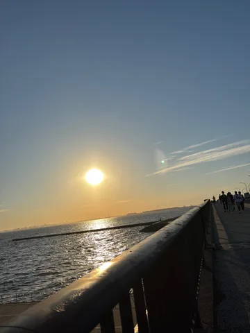水平線に沈む夕陽、海辺の散歩道