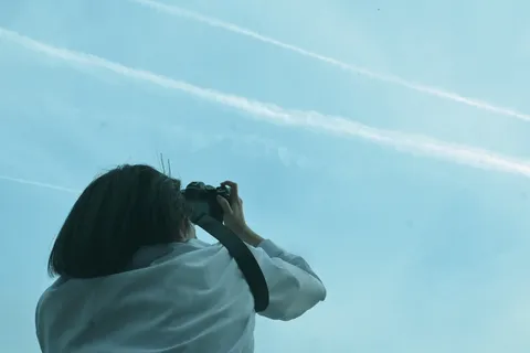 飛行機雲を追いかける背中