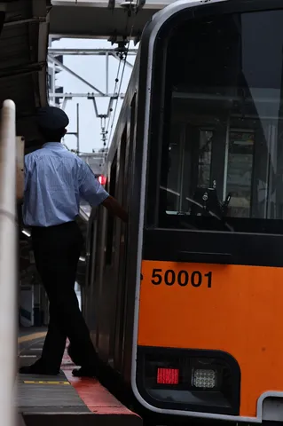 停車中の車掌さん、乗客を待つ静寂
