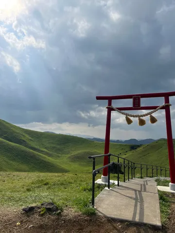 緑の丘と朱色の鳥居、空への誘い
